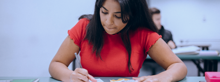 Aluna escrevendo no caderno